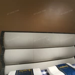 Soft Upholstered Bed with Embossed Brand Mark, Rich-Patterned Natural Wood Veneer Trim & Polished Gold Stainless Steel Accents